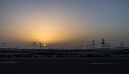 Fototapeta na wymiar Silhouette of high voltage power lines in Dubai