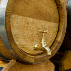 Wooden barrels for wine with a tap of yellow metal.
