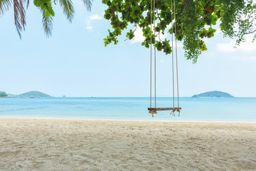 Tropical beach and swing under trees