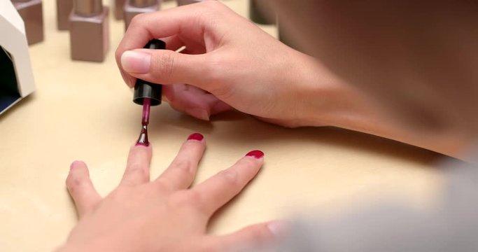 Woman applying nail polish at home