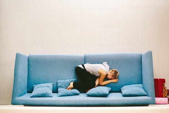 Casual pretty woman wearing short hair lying on blue sofa at home