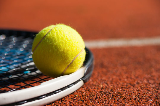 Tennis racket and ball on court 