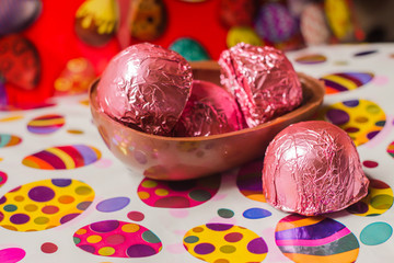 Trufas cor de rosa e composição de bombons de chocolate na páscoa com fundo colorido 