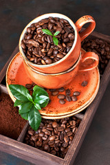 Coffee beans in ceramic mug on dark background