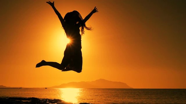 silhouette of girl jumping at sunrise