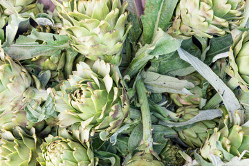 Artichokes on market stall. Green healthy vegetables.