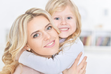 young happy woman with little girl embracing