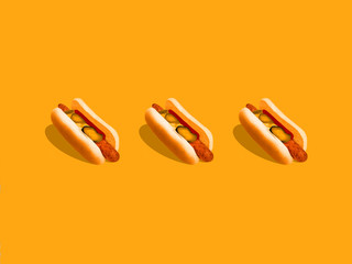 Hot dog photo Three hot dogs with mustard and pickled cucumbers are lying on a bright yellow background Trendy mockup for posters and banners with copy space