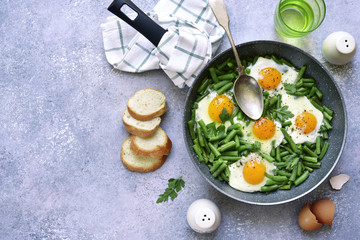 Healthy vegetarian breakfast : fried eggs and asparagus bean in a skillet.Top view.