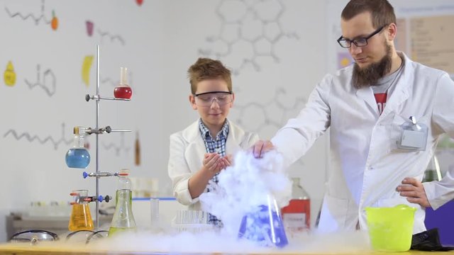 Two laboratory assistans explores dry ice and his impact on the acid
