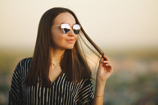 portrait of young woman in sunglasses with reflective glasses.
