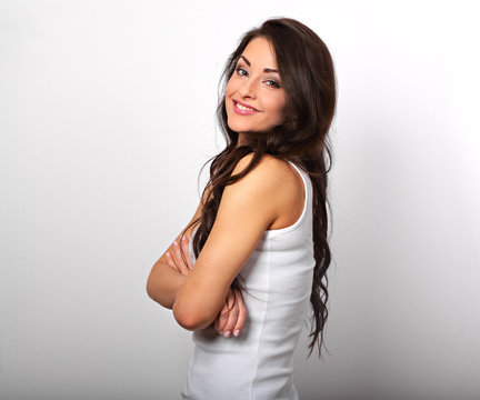 Beautiful positive happy woman in shirt with toothy smile folded arms the long brown hair on white background.