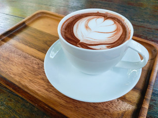 Hot chocolate cup and cream topping with wooden background.