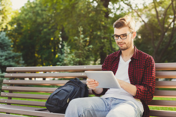 Fototapeta premium Surprised man in the park with tablet oudoors