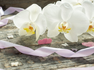White orchid Phalaenopsis on a wooden background Pink ribbon heart