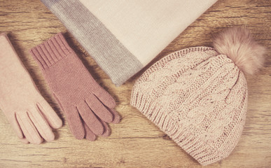 Warm winter knitted clothes on a wooden background.