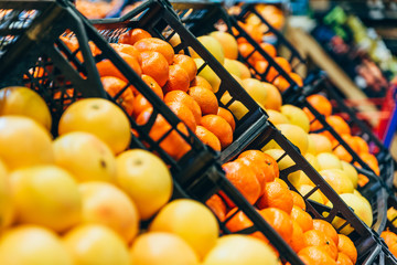 oranges mandarins on shelf of store. citruses in boxes in shop. grocery shopping