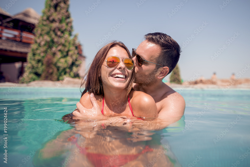 Wall mural Couple having fun in swimming pool