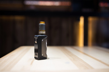 vape stands on a wooden table. Accessory store for vape