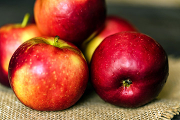 Fototapeta na wymiar Whole ripe red apples on burlap napkin close