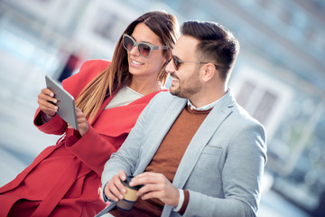Loving couple with tablet and coffee to go
