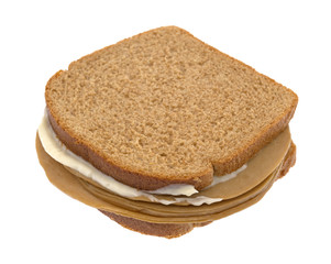 A tofu turkey slice sandwich on wheat bread with mayonnaise isolated on a white background.