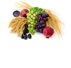 Grapes, dates, garnets, figs, barley and wheat on a white background with space of text. Top view.