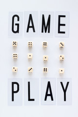 GAME PLAY words and gaming dice in row on white background. Concept for banners, web pages, games, game board, presentation. Top view.