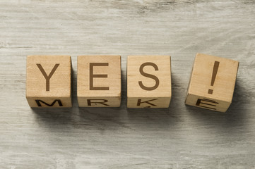 word YES written on wooden cubes