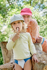 Little boy eating ice-cream on weekend with his mom