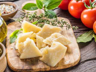 Parmesan cheese on wooden cutting board. Food background.