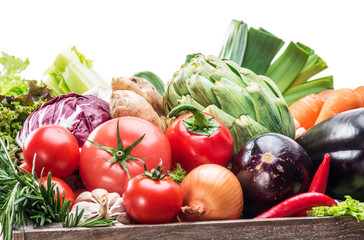 Fresh multi-colored vegetables in wooden crate.