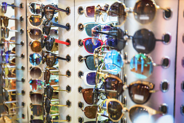 Many fashion sun glasses in shop for sale, selective focus