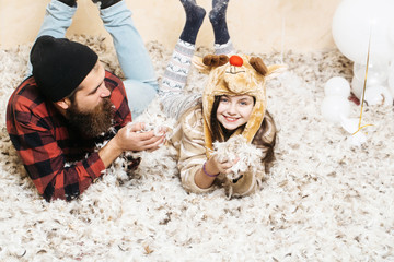 Christmas father and daughter lie in feathers. Christmas family celebrate winter holidays