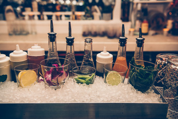 Ingredients and syrups for cocktails at bar counter in the the nightclub