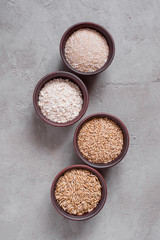 Fototapeta na wymiar Various types of oats in the bowls on gray textured table