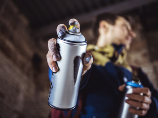 street art artist holding spray paint can in the hand close up