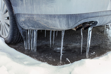 Icicles on exhaust of dirty car that was not used for some time, illustrating very low temperatures...