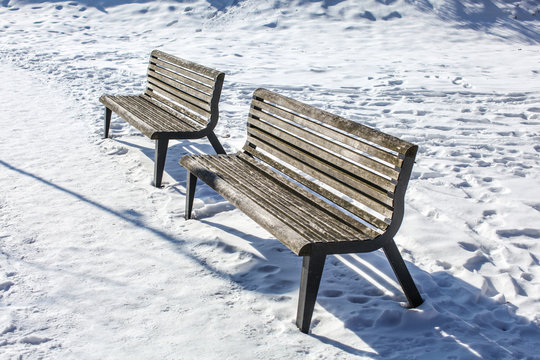Two empty benches on snow covered ground © Lubo Ivanko