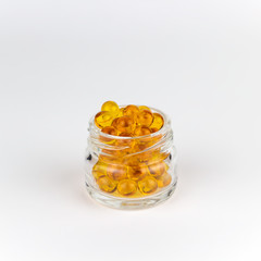round orange vitamins glass jar white background