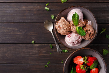 Portion of ice cream and strawberry on wood
