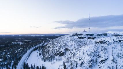 Aerial drone view of road in idyllic winter landscape. Street running through the nature from a birds eye view.