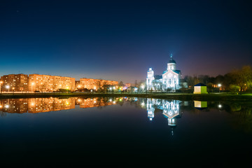 Evening View Of Illuminated Alexander Nevsky Orthodox Church And Residential Area Behind City Lake.