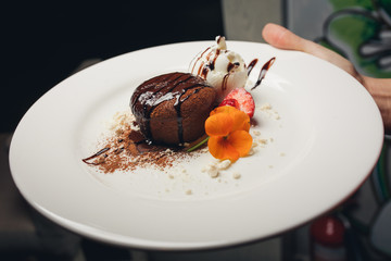  GoogleBingchocolate dessert with ice cream decorated with orange flower on a white platechocolate dessert