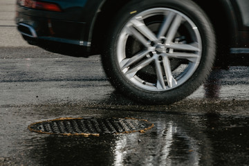 wheel of a car passing by puddle
