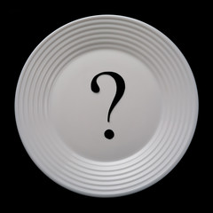 Empty white plate on a black background with a question mark, top view