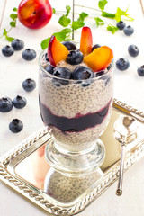 Chia pudding with yoghurt, jam, blueberries and plums
