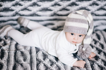 Small baby boy lying on stomach and raising his head awhile looking surprised and smiling cute, newborn