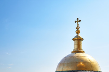 Fototapeta na wymiar Dome of the Orthodox Church in the afternoon on a background of blue sky with clouds.