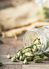 Dry whole cardamom, vintage wooden background, selective focus